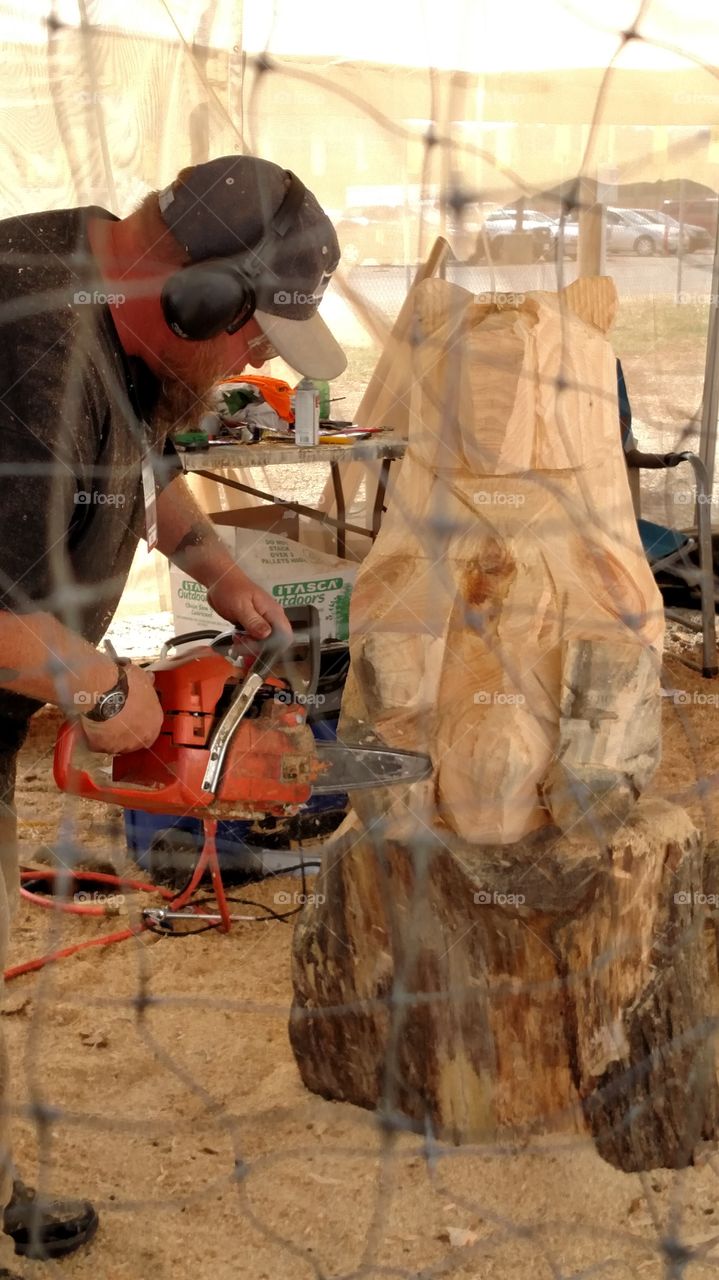 working with a chain saw this guy is creating some beautiful works out of a block of wood