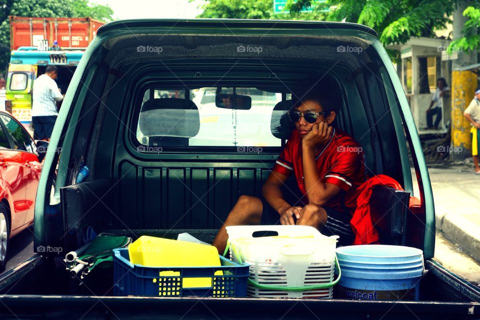 A passenger at a back of a pick up truck