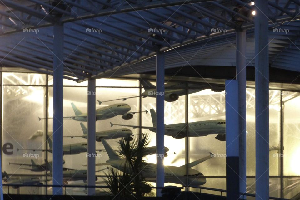 Arrival at the airport from the car park is via a covered walkway. Passengers are greeted at the airport by large display cases decorated with airplanes.