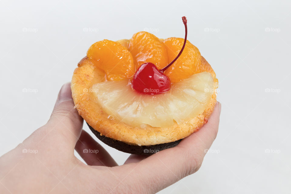 Person's hand holding fruits cake