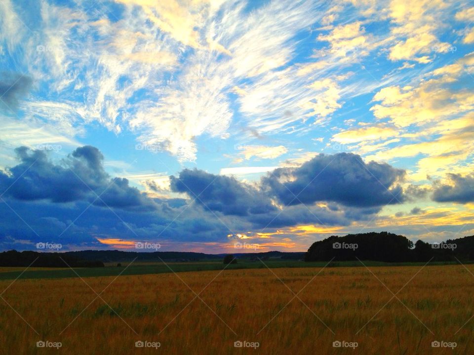 View of field against dramatic sky