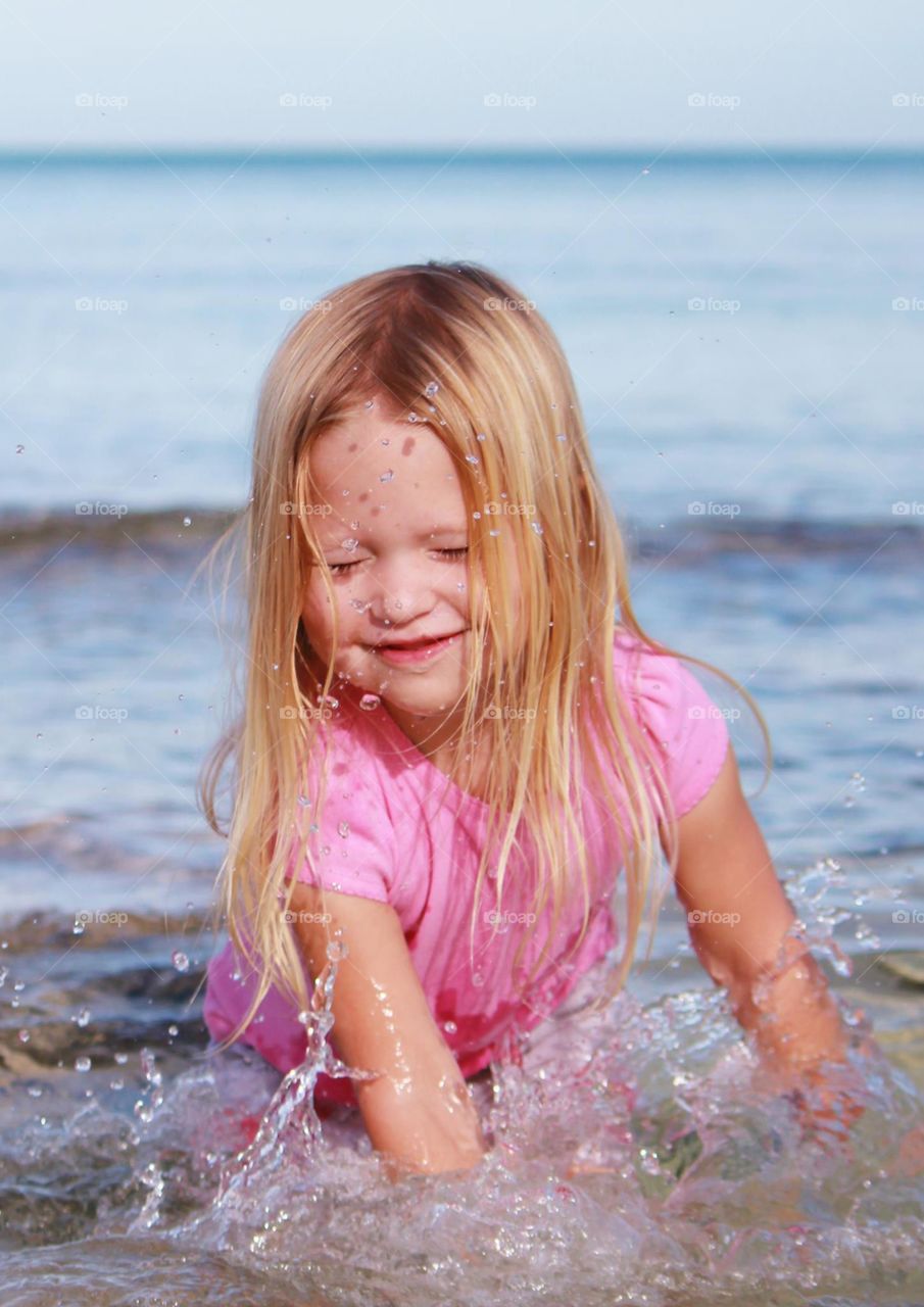 Little girl splashing in the ocean 