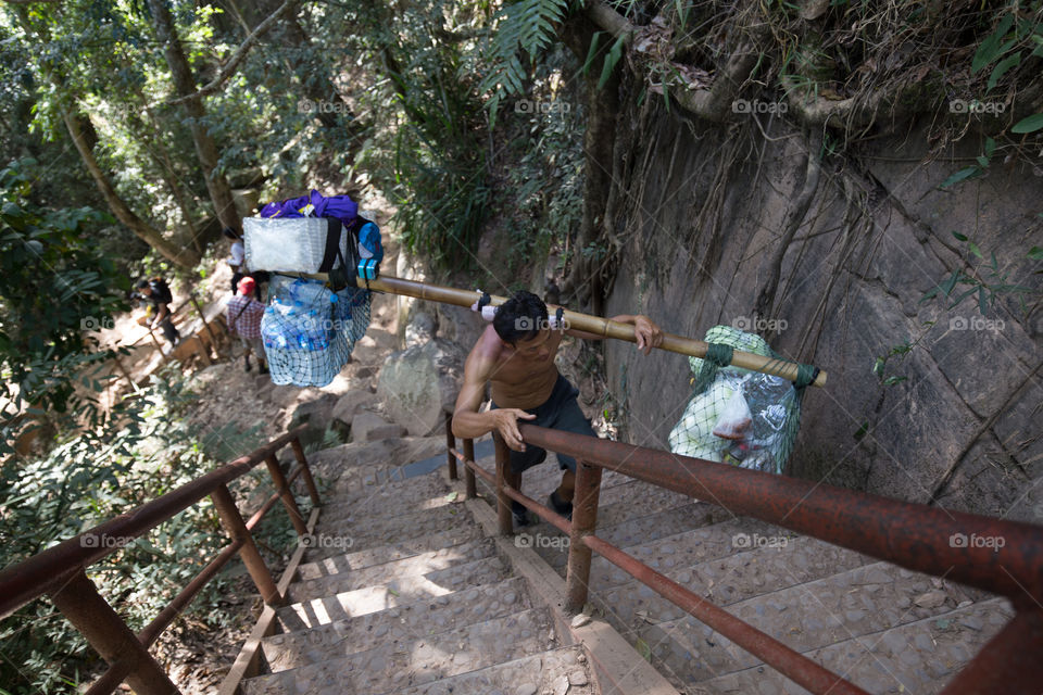 Man carrying stuff on the shoulder 