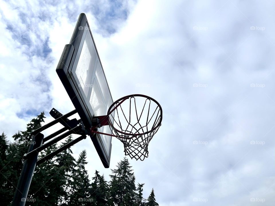 Basketball hoop on the cloudy sky background 