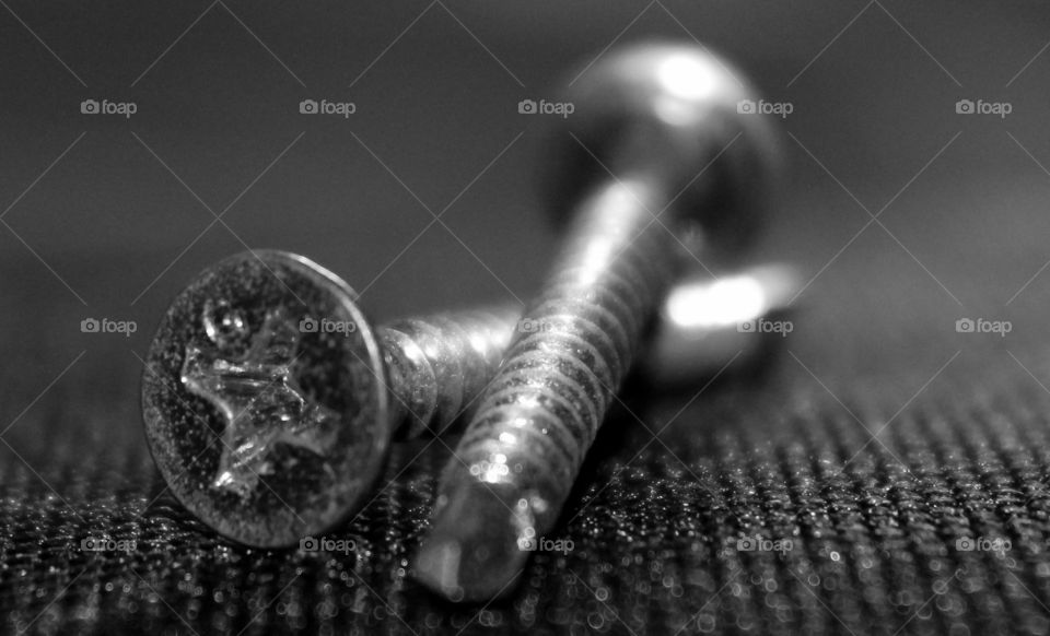 This is a picture up close picture of a black and white photo of two screws.