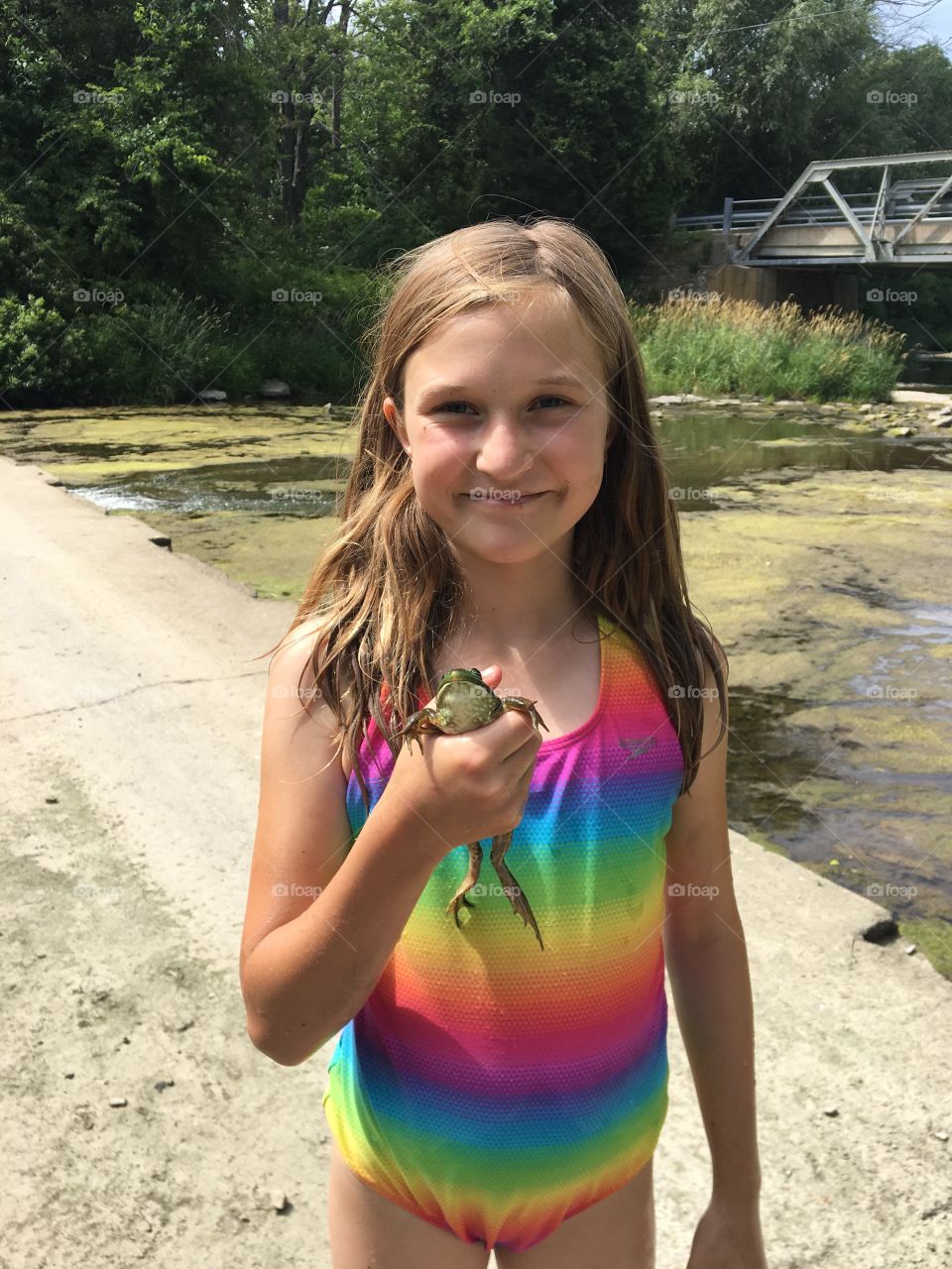 Summer camp and nature should go hand in hand. This bright, and brightly dressed girl caught a frog which was promptly released after a close and gentle examination. 