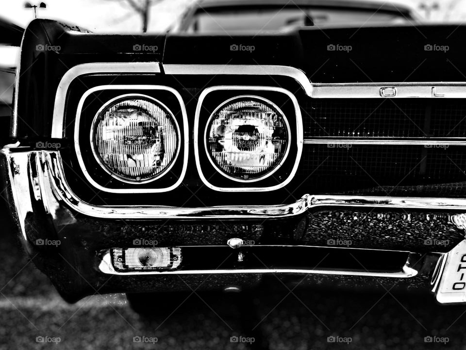 Classic American car at a car show, American activities in the summertime, pride of America, vintage American made cars, black and white image of a classic car, closeup of a cars front end, headlights on a classic car, American made products