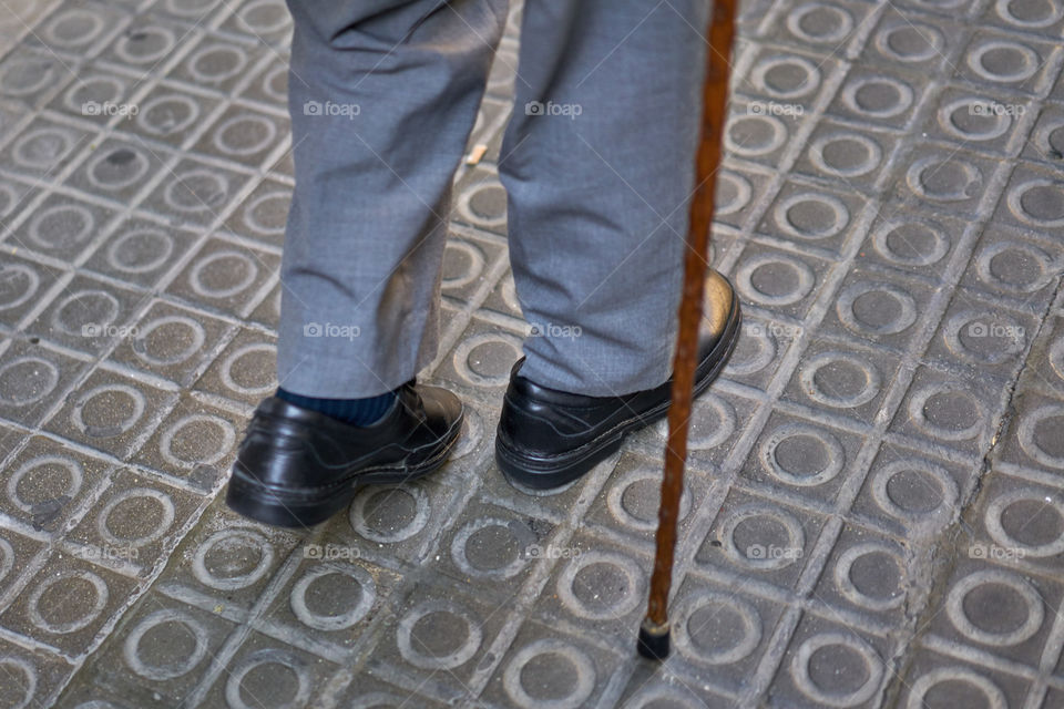 Elderly man walking with a walking stick 