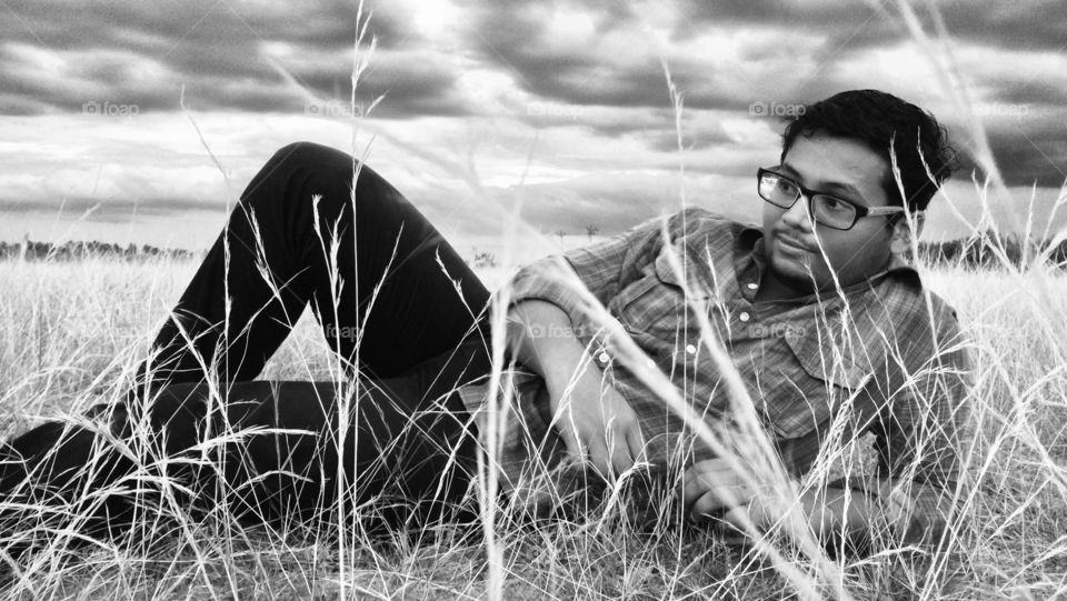 Man with spectacles lying on grass