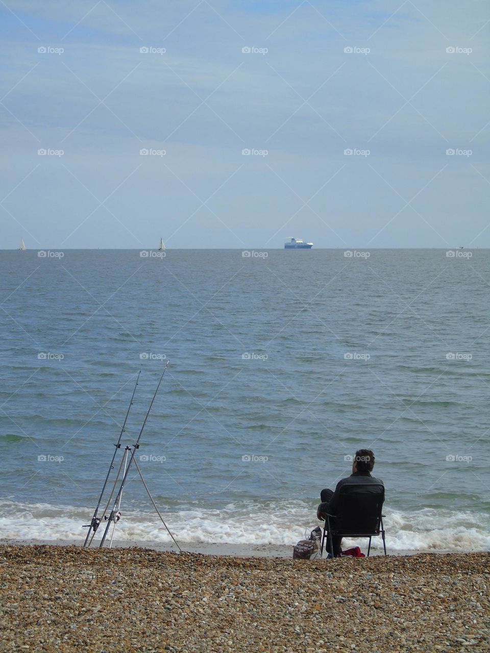 Lonely fisherman on the beach, Felixstowe, UK