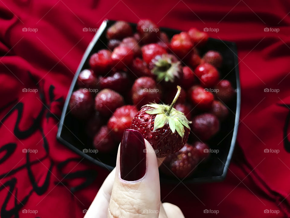 Female hand holding a strawberry 