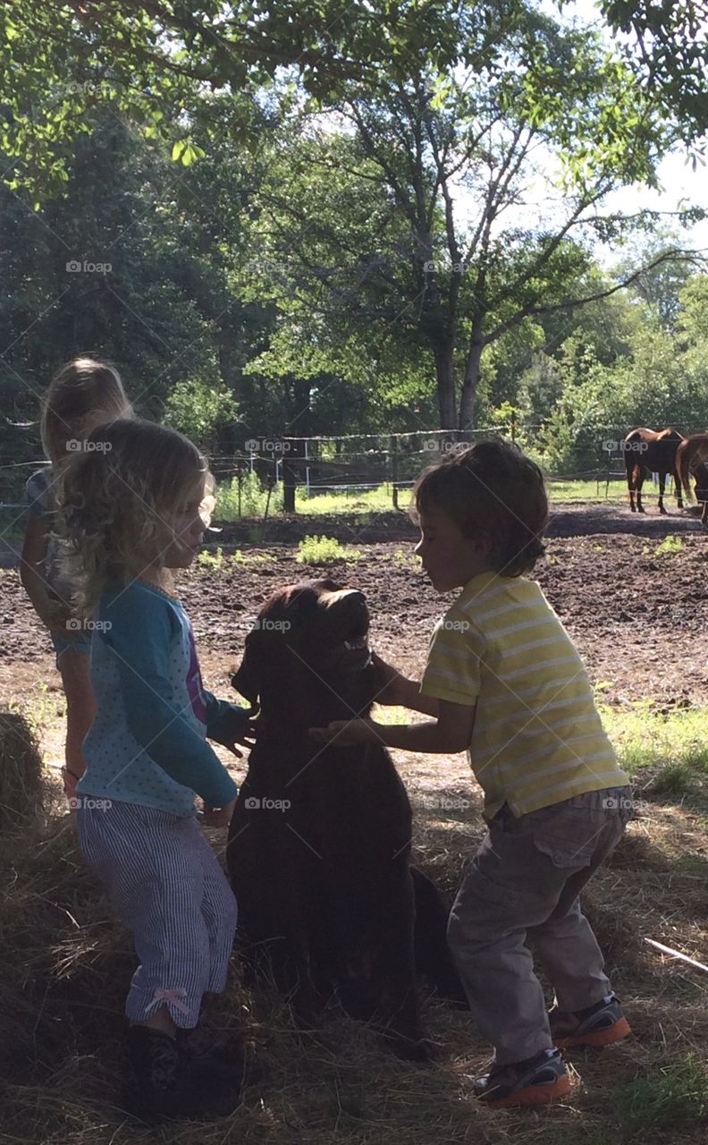 Twins playing with Choco the farm dog
