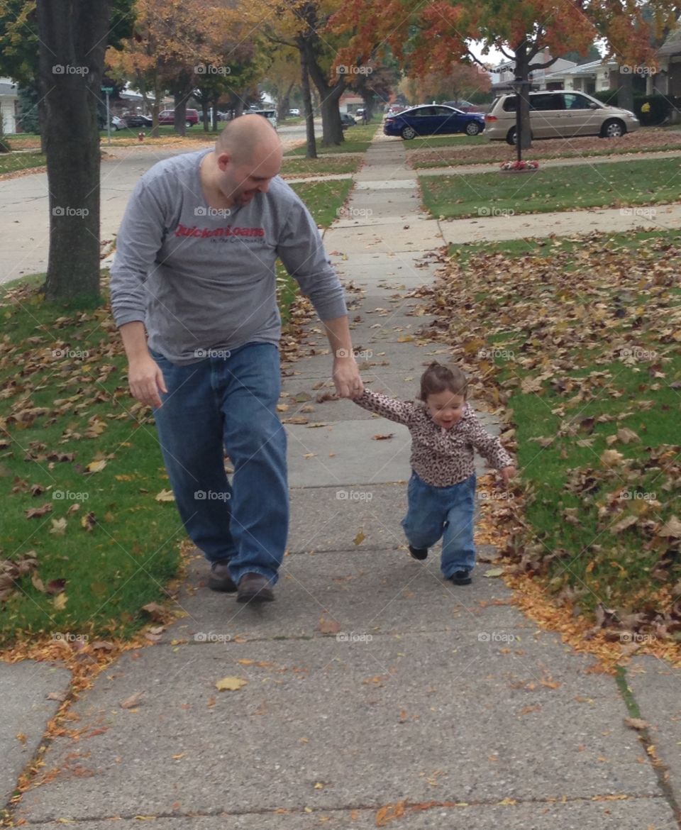 Daddy walking with daughter on fall day