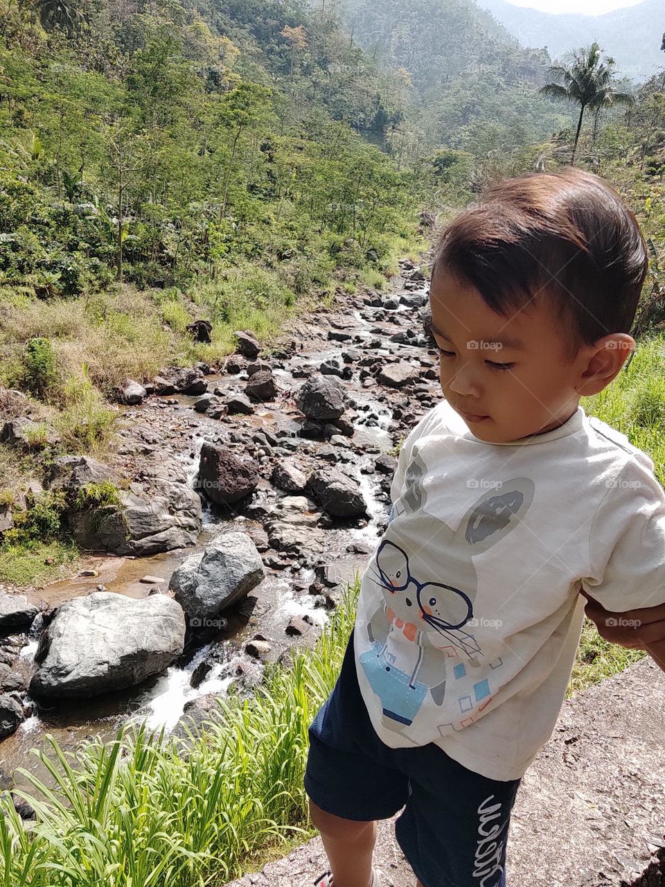 My son is walking by the charming river