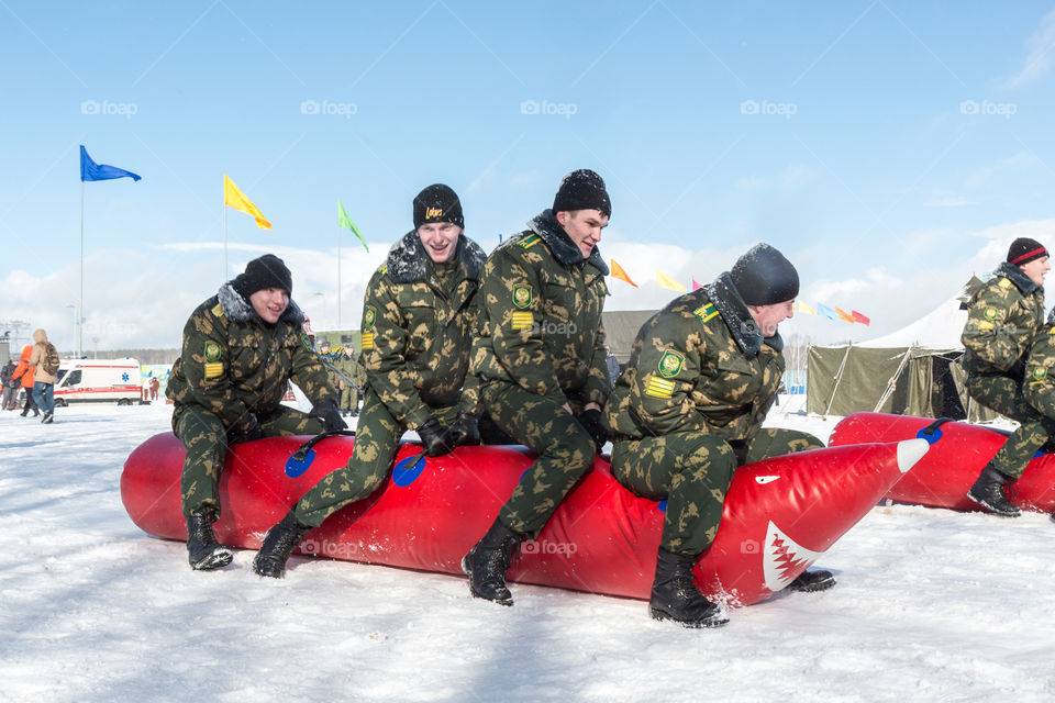 military cadets compete by jumping on an inflatable toy