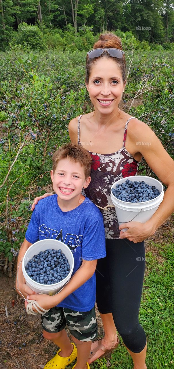 Mother and son blueberry picking duo