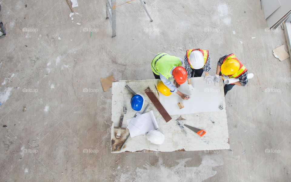 Top view, engineer and architecture team talking about building plan