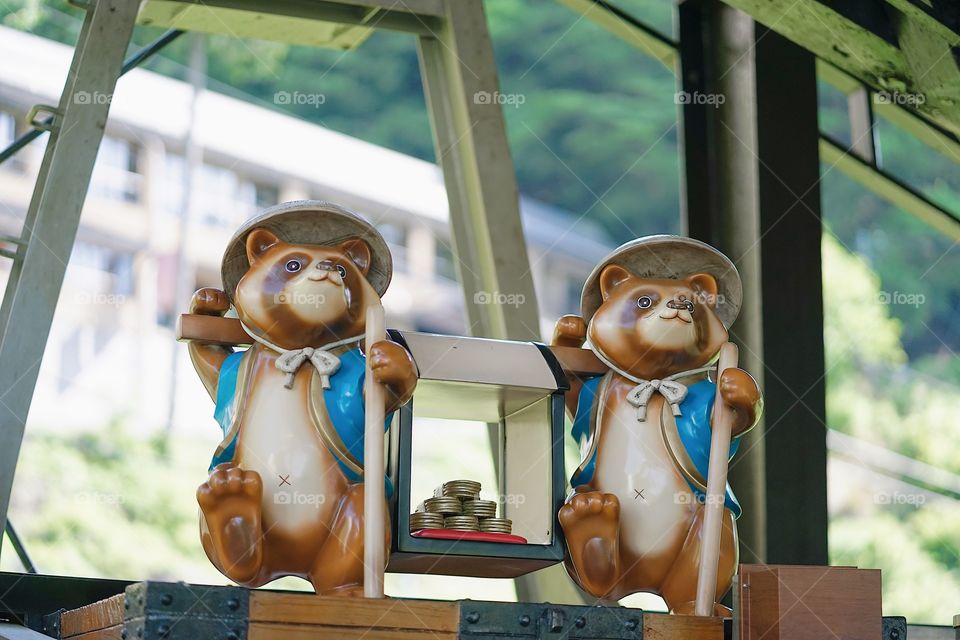 Tanuki statues. Tanuki is a Japanese animal looks like a raccoon, existed in Japanese story telling, mythology and many literatures. Selective focus on the right Tanuki's eyes.