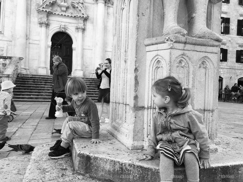 Boy eating ice cream and little girl watching in Old Town Dubrovnik, Croatia 