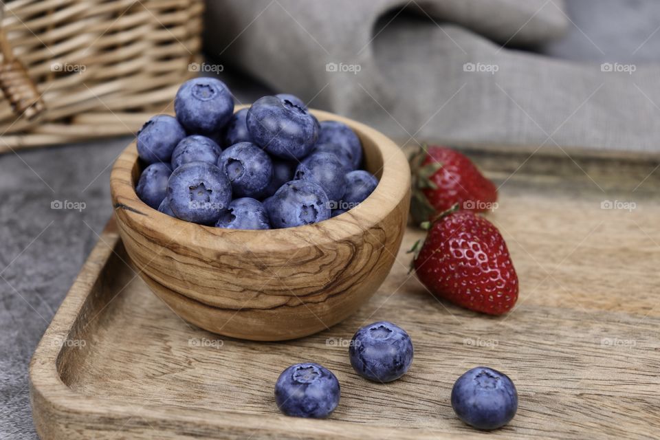 blueberries and strawberries in a wooden bowl