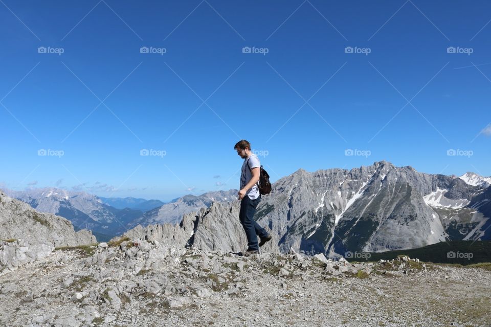 Belo Homem amador fazendo montanhismo em Alpes austríacos, cidade Tirol, com céu azul turquesa 