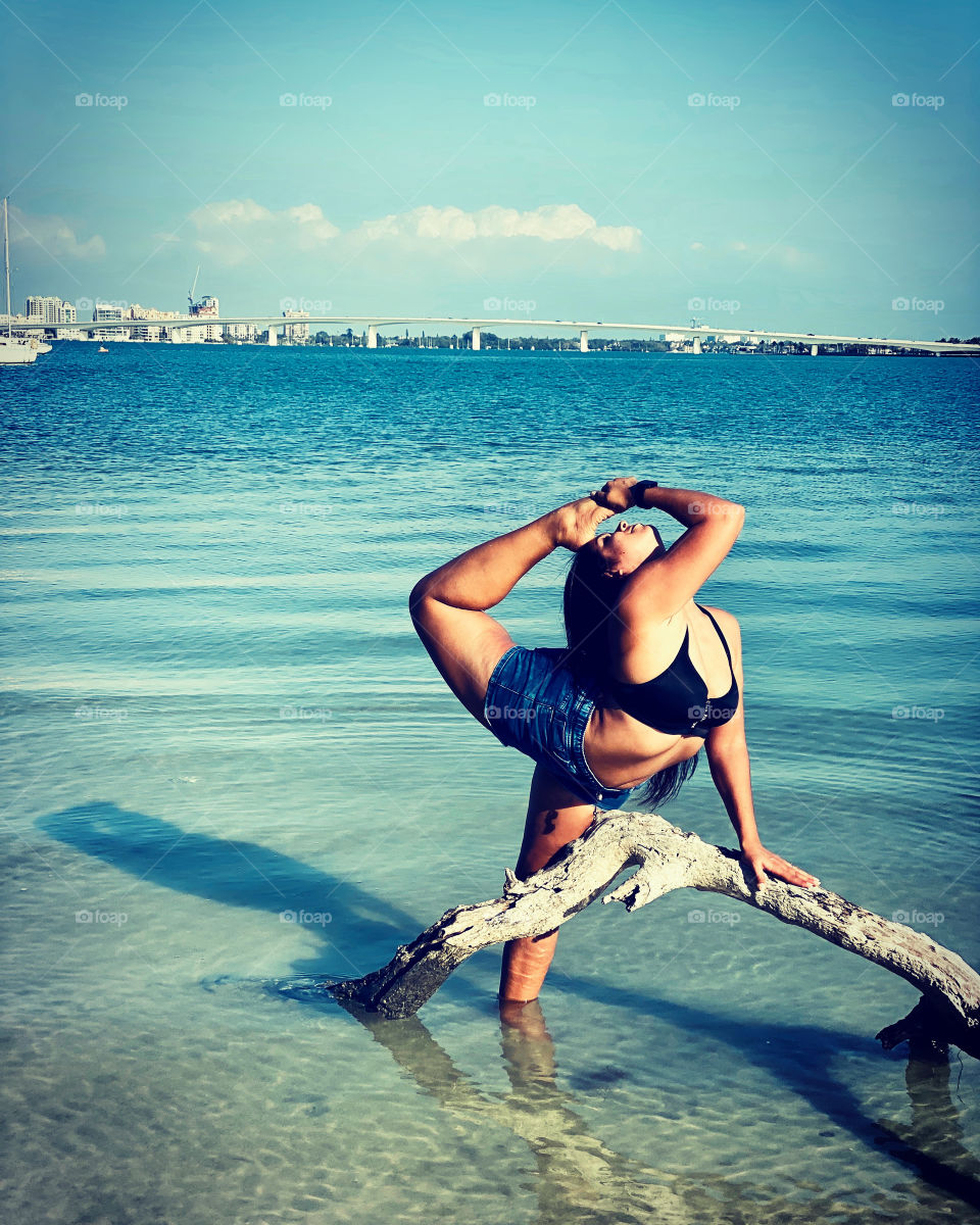 Girl working on flexibility by the water