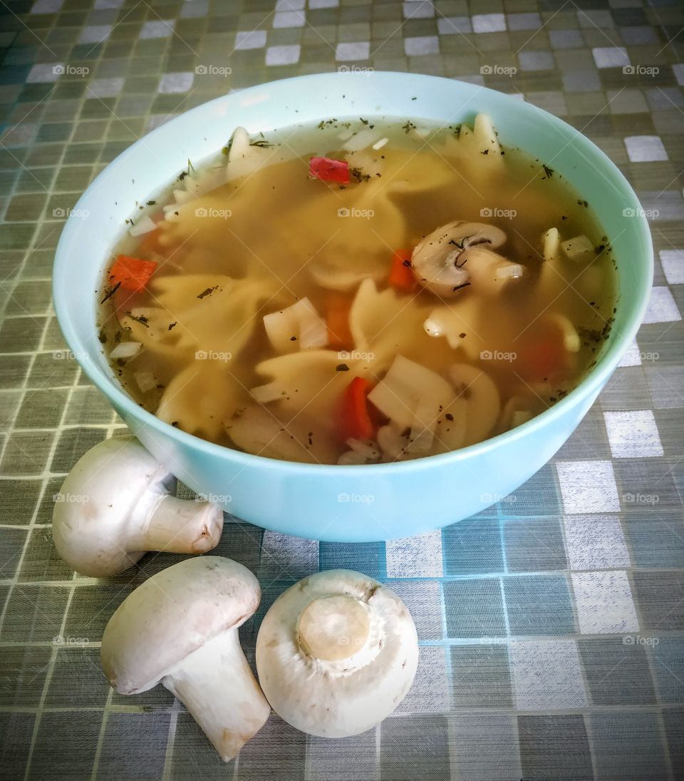 Delicious soup with mushrooms and farfalle