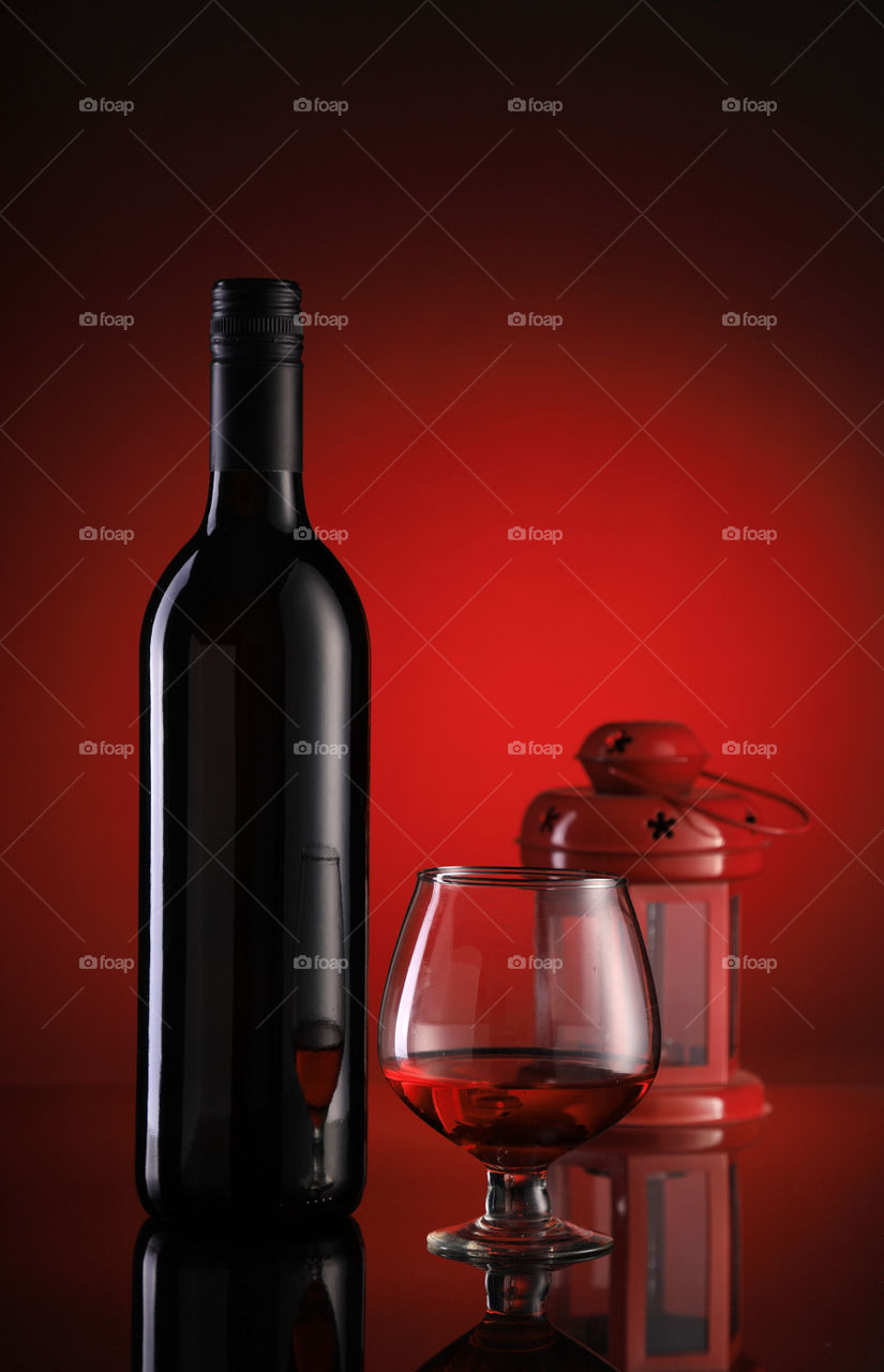 Red wine bottle and glass with a red lantern