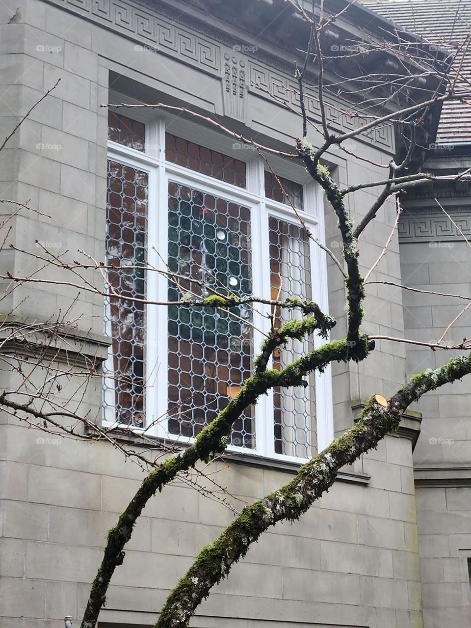 An impressive window set into one of the gray walls of the Pittock Mansion in Oregon