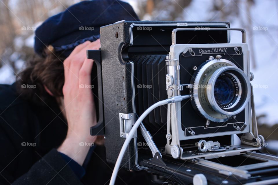 A man uses the old fashion photography equipment of a film camera to capture his image 