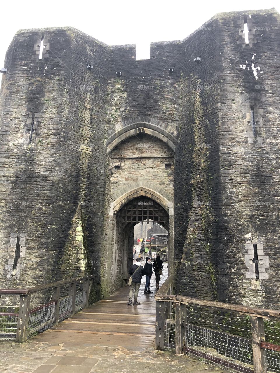 People entering Caerphilly Castle for a tour and an up close and detailed view of the magnificent entrance to this magical piece of history.
