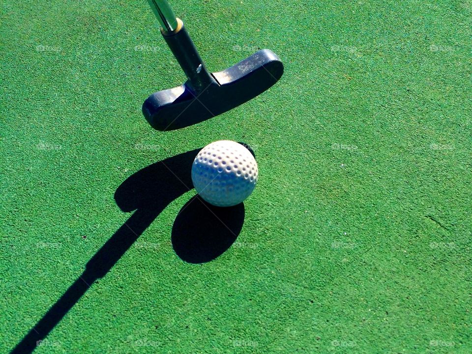 Close-up of golf ball at edge of hole