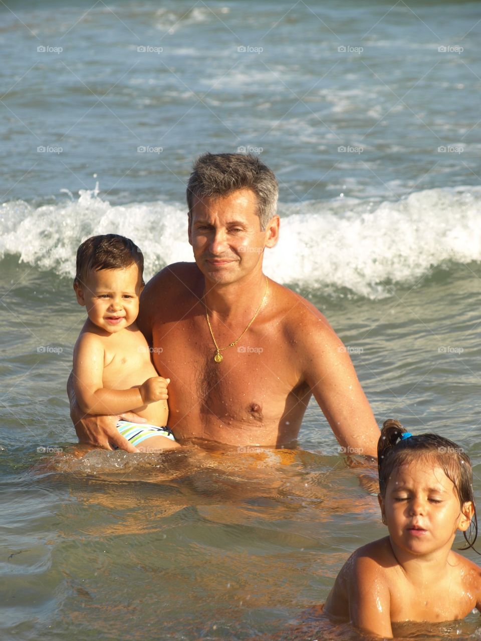 Father with children in the sea water