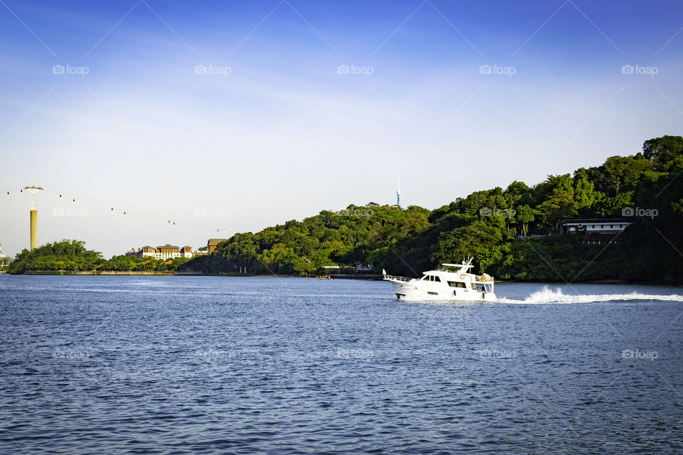 Speedboat cruising on the water. Green island in the background.