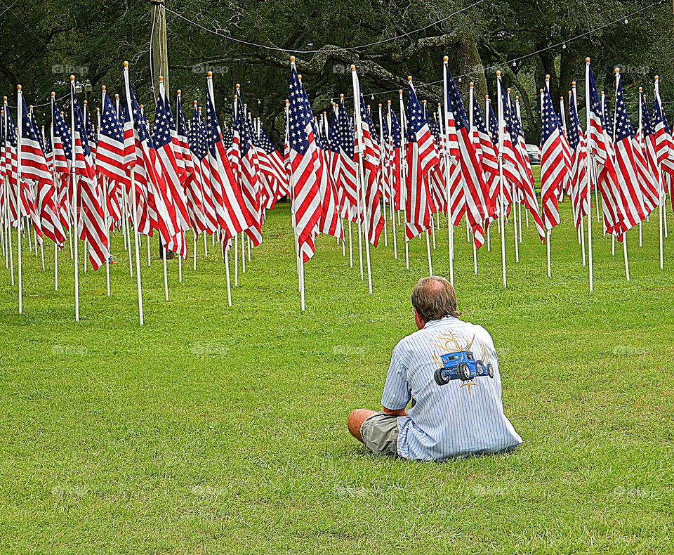 A father sits in silence wishing his deceased son was still alive, instead of a American flag that represented him. 