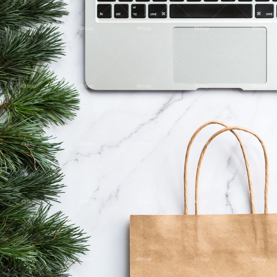 Holiday shopping. Flatlay items. Laptop, bag, Christmas tree 