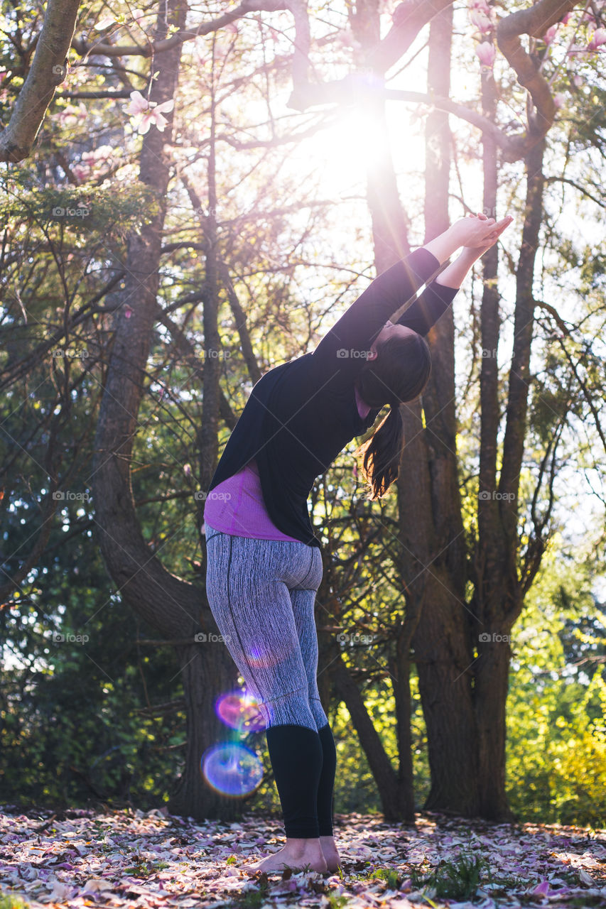 A woman Working out doing some yoga in the backyard 