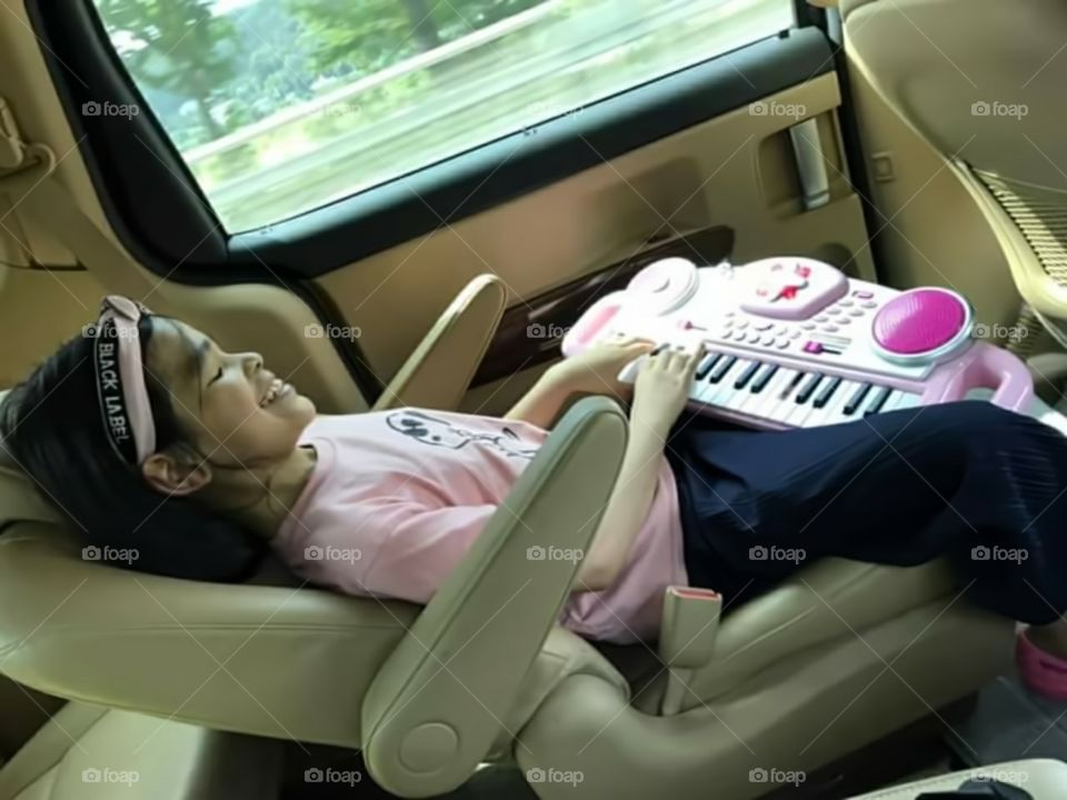 shes smiling , laughing and giggling for the happiness of being outside while listening the sounds of every notes that she played in her favorate pinky piano.