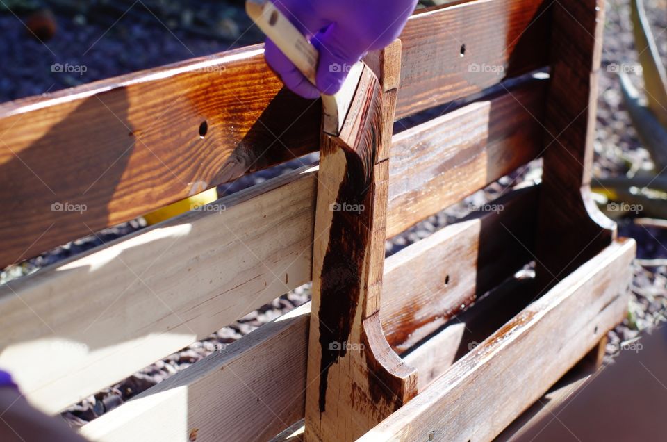 Applying wood stain to a homemade wine rack.