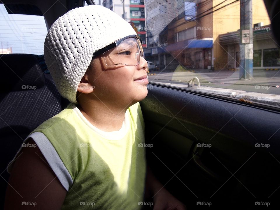 young boy wearing a bonnet inside a car