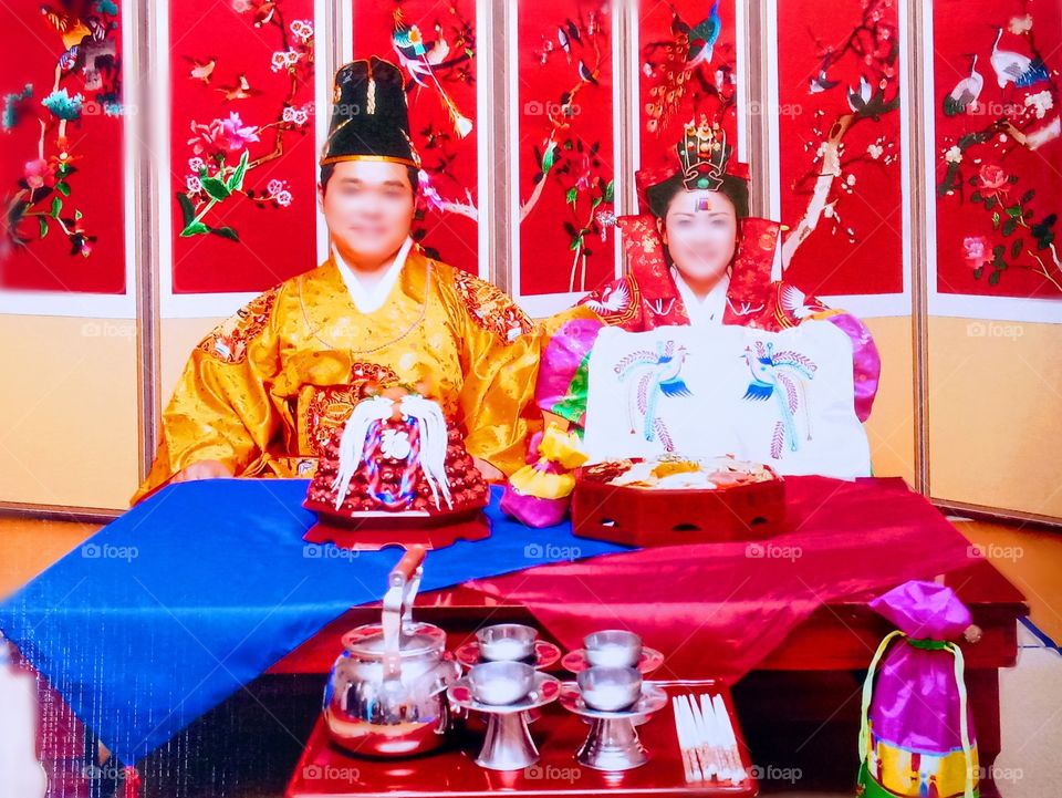 This is the traditional korean wedding.
The dress called ""Hanbok.""
The Dates and chestnuts symbolize Fertility for the woman.
The number of dates that they will catch, its the number of babies that they will have.
