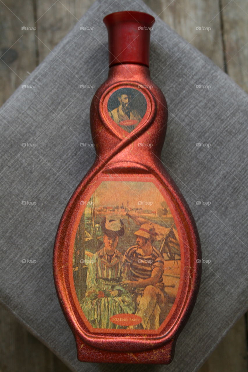 A beautifully unique red, curved vintage liquor bottle
