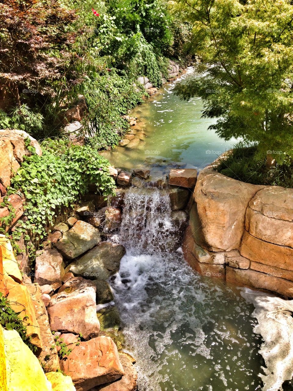 Above the falls. Waterfall at an outdoor garden exhibit 