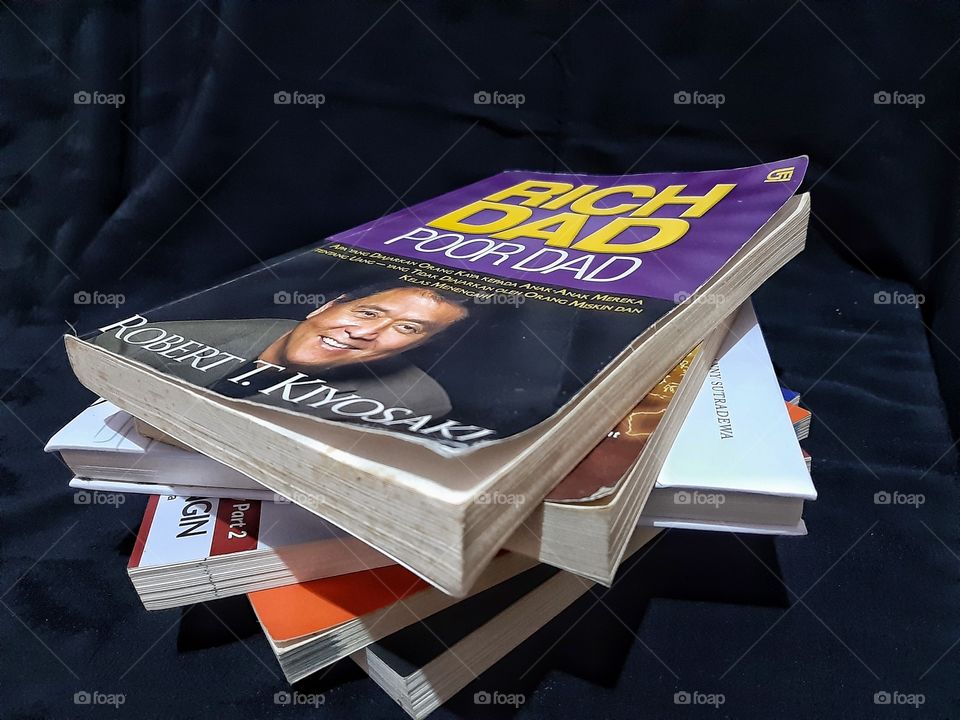 a pile of financial books that can hel people to be wealthy if what it is taught is done by them.