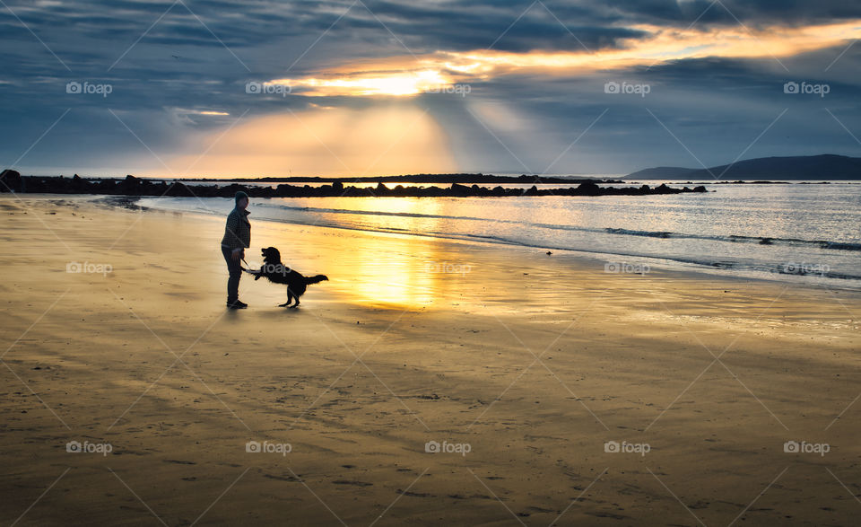 Lady with dog at Silverstrand beach in Galway, Ireland