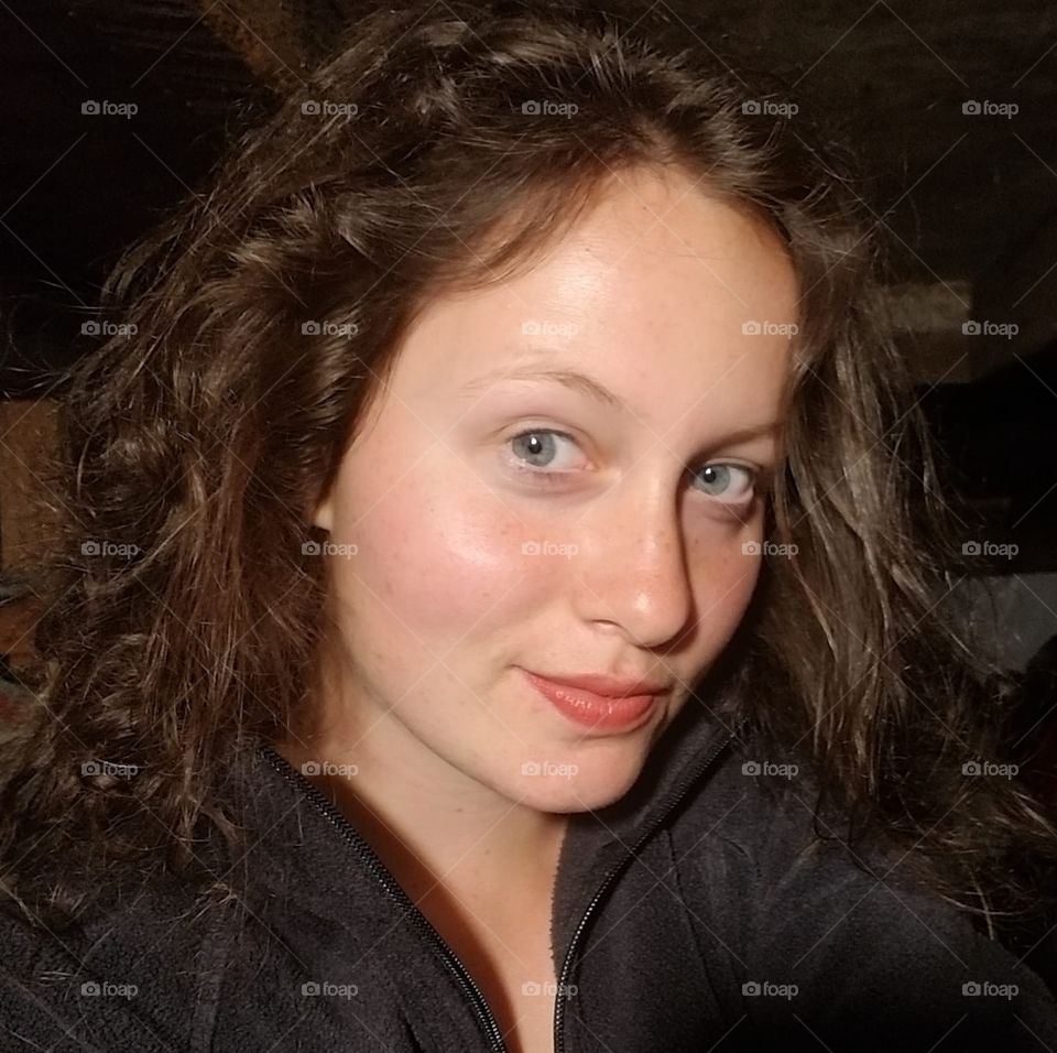 Unfiltered selfie/self portrait at night.  
Young woman with wavy dark hair and blue eyes.
#truephotos