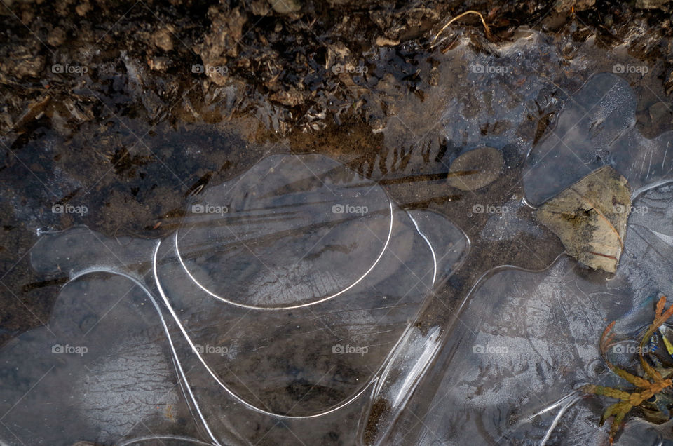 Closeup of frozen water on ground during winter in Cracow, Poland.