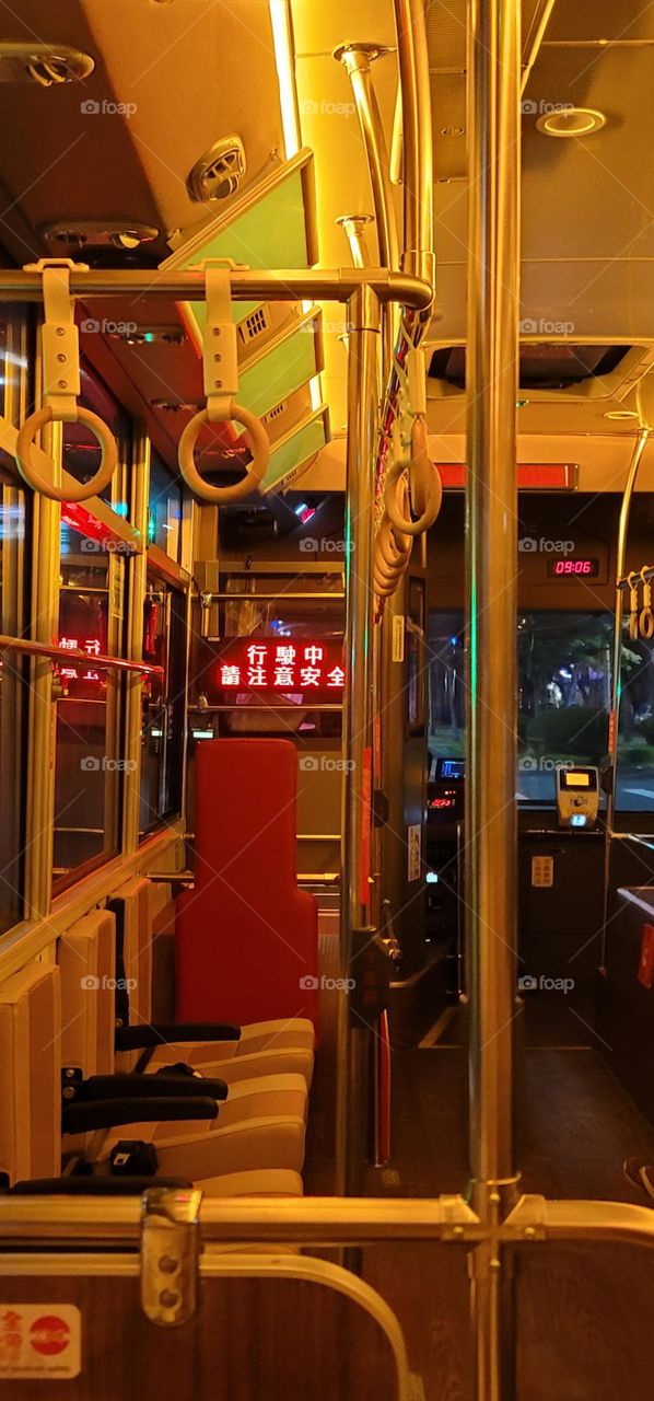 A retro-style bus with a warm yellow light interior. The marquee reads "Please pay attention to safety while driving" in Chinese