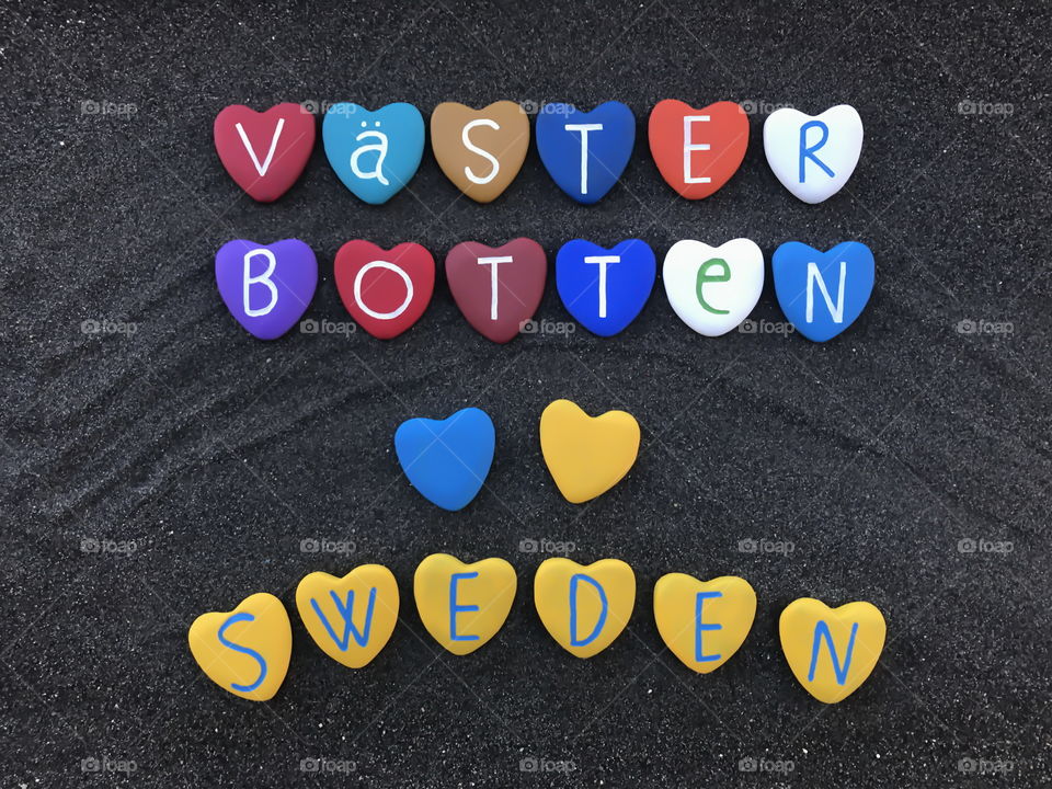 Västerbotten County, Sweden, souvenir with  a composition of colored heart stones over black volcanic sand 
