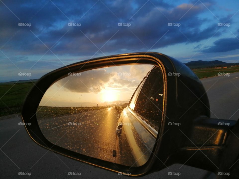Rearview mirror with sunset in the background